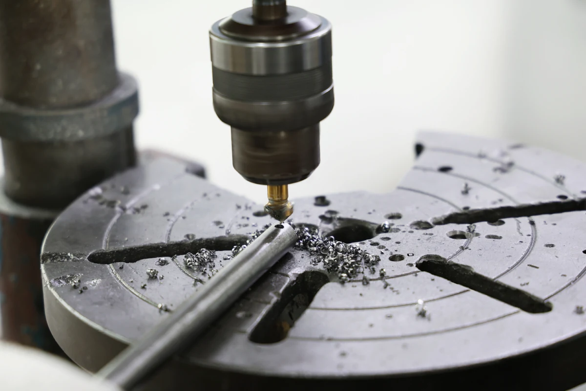 Countersink tool on a drill press chamfering the end of a small steel rod