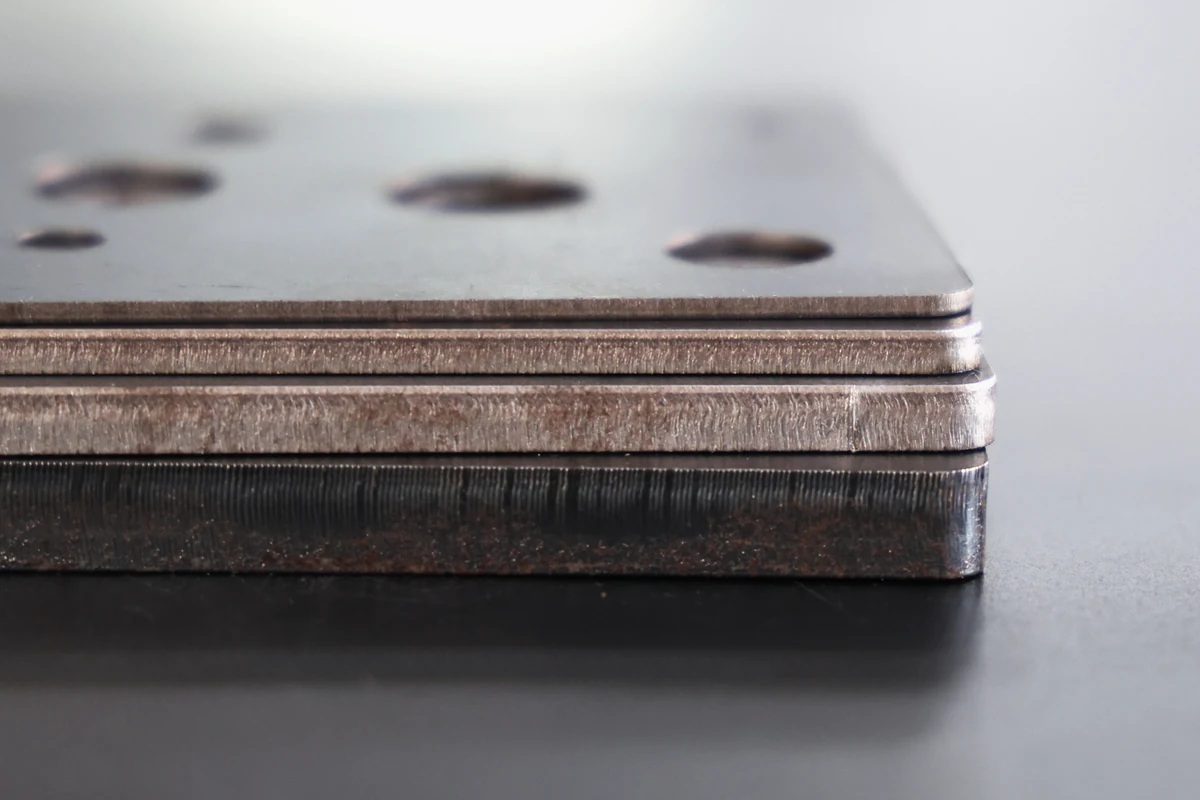 Q235 laser cut steel plates at 2, 4, 6 and 10 mm stacked and photographed edge-on