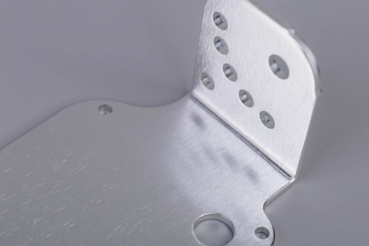 Clear anodized aluminum sheet metal bracket with formed flange and multiple mounting holes