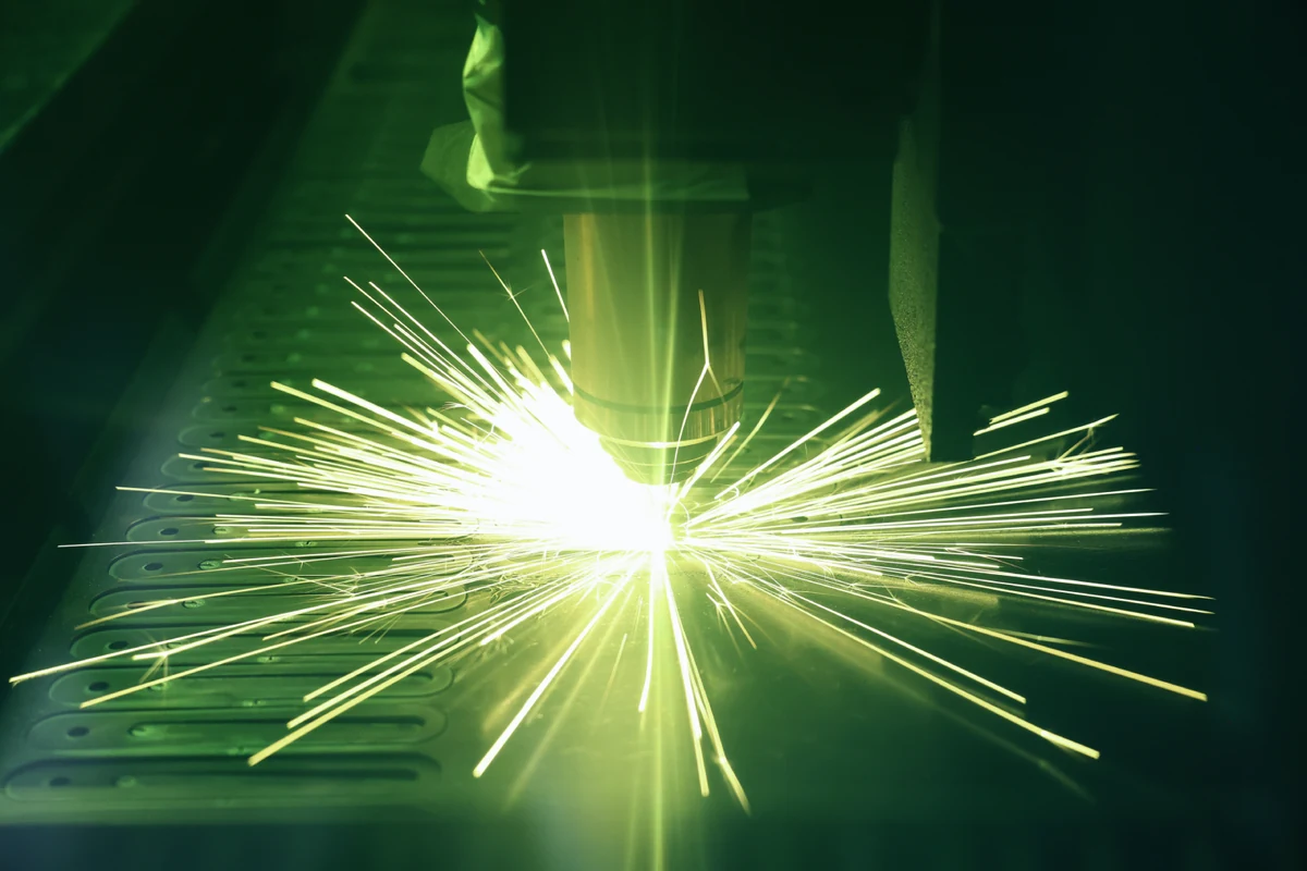 Fiber laser cutting steel sheet with sparks at the cut front