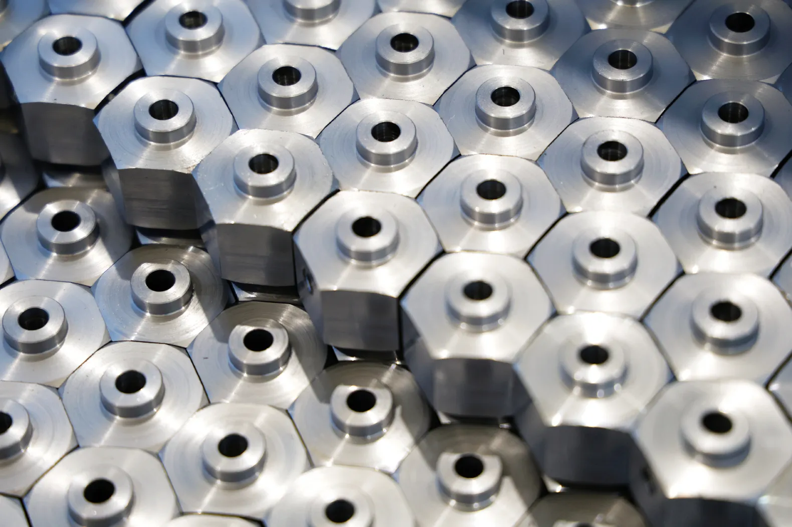 CNC turned hex parts with milled flats and center holes arranged in rows