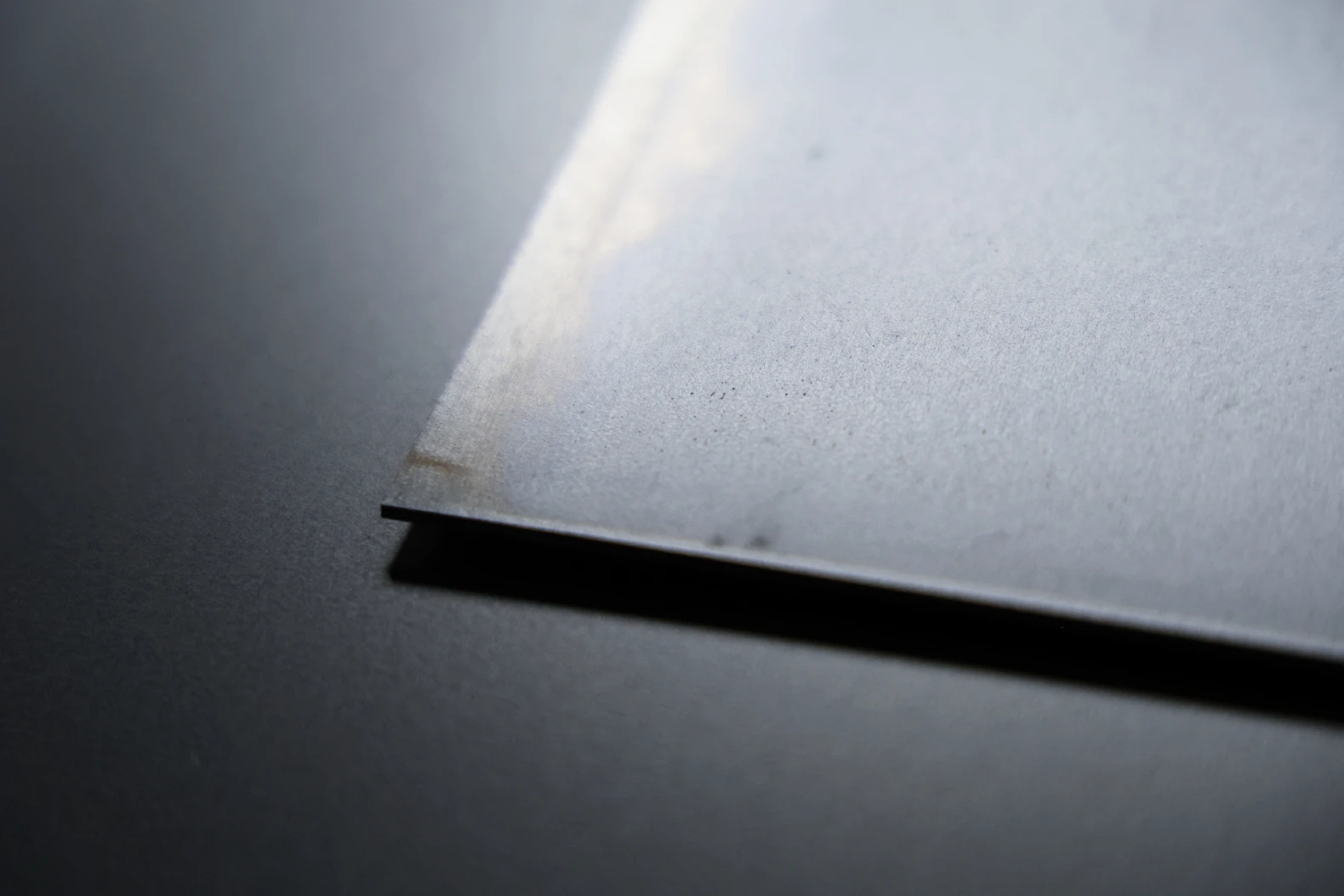 Cold rolled steel sheet corner showing a smooth uniform grey surface and a clean square cut edge