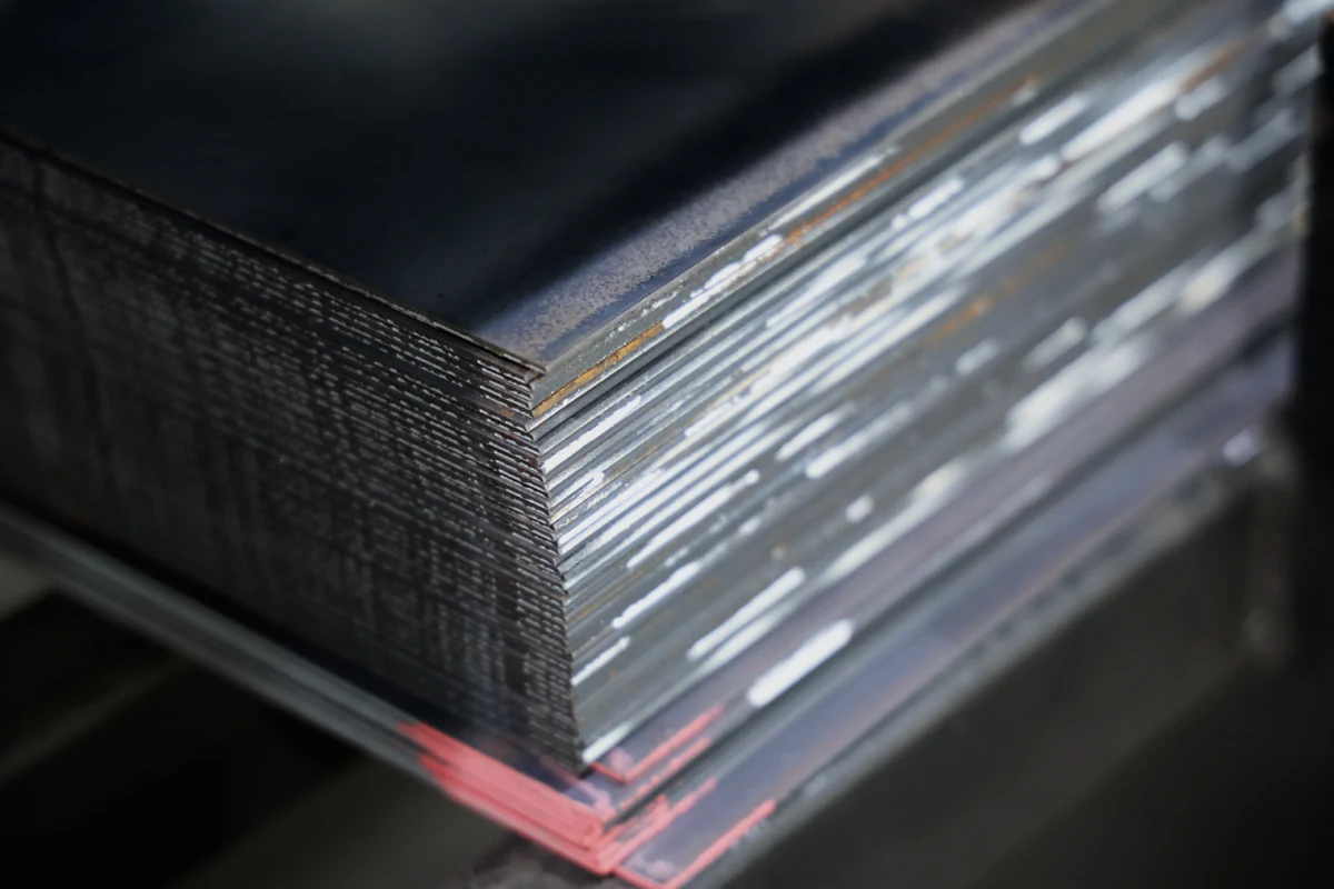 Stack of hot rolled Q235 steel sheet showing dark mill scale surface